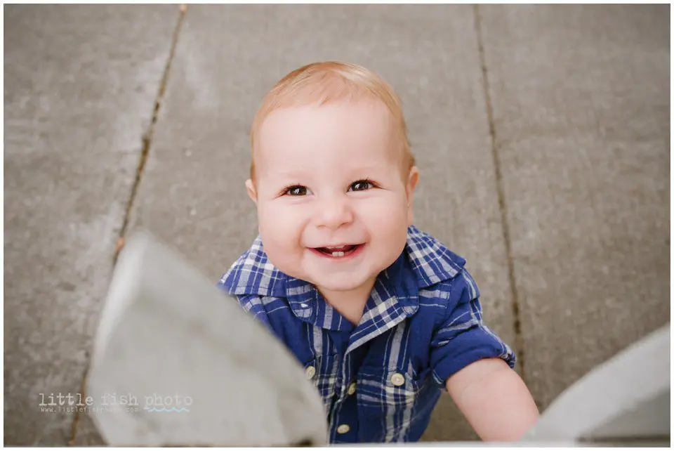boy smiles while looking over fence
