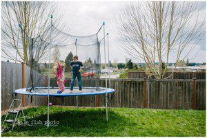 brother and sister on trampoline - family documentary photography