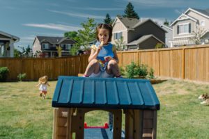 girl eats popsicle on playhouse