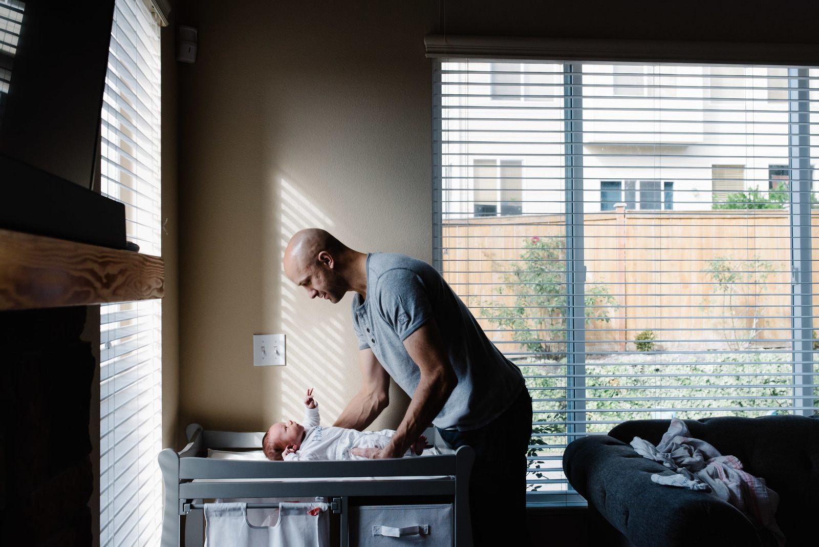 father picks up baby from changing table