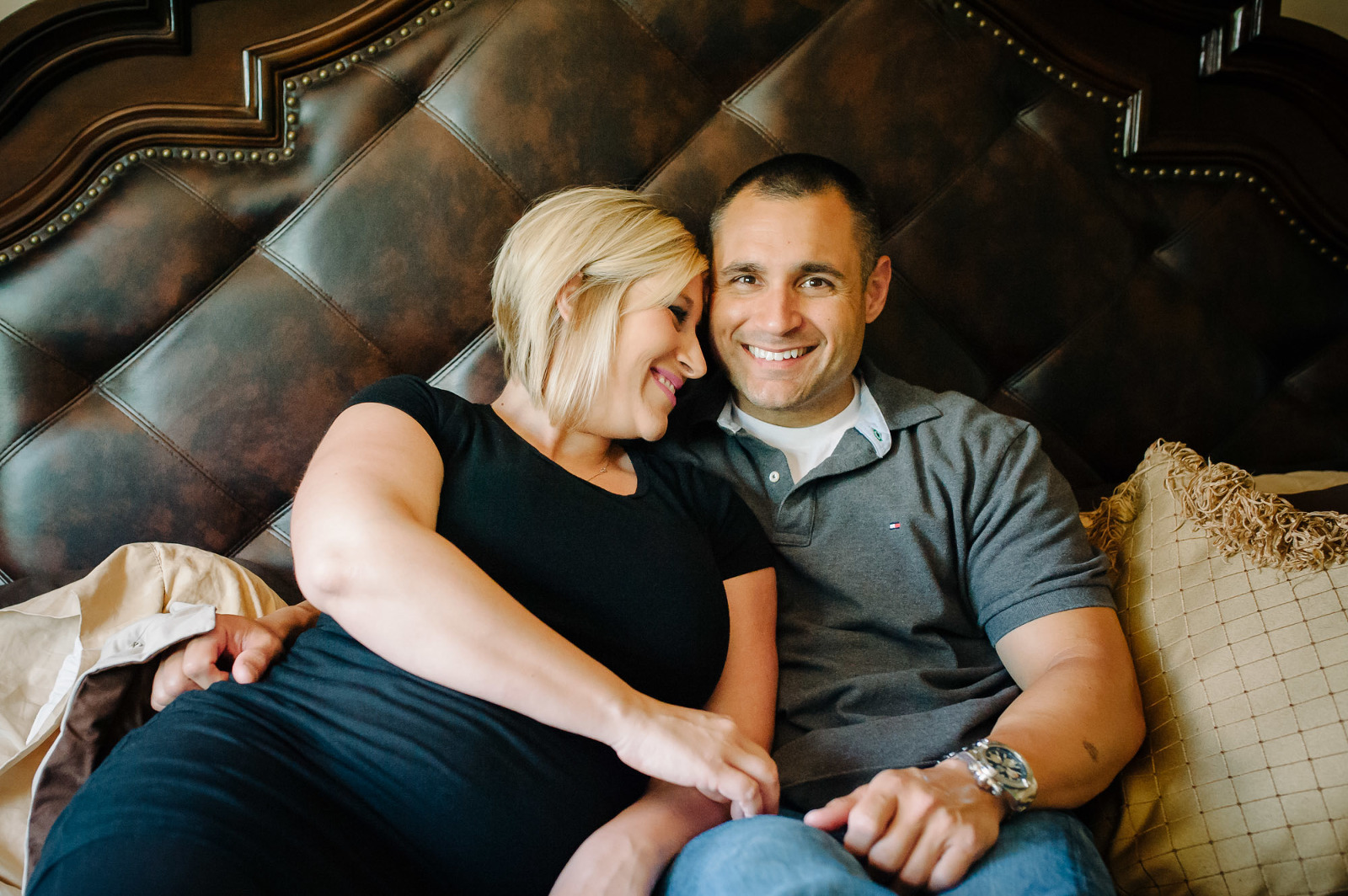 mother and father to be snuggle in bed