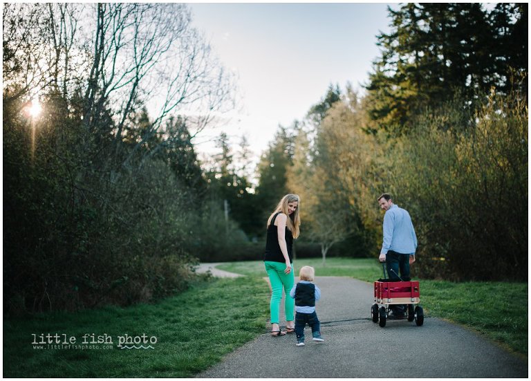 Family of three walking on paved trail with wagon in park on Bainbridge Island