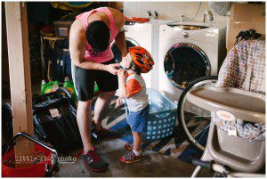 dad helps son with bike helmet