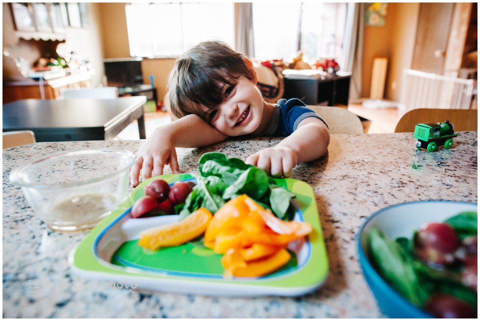 boy with dinner plate in kitchen