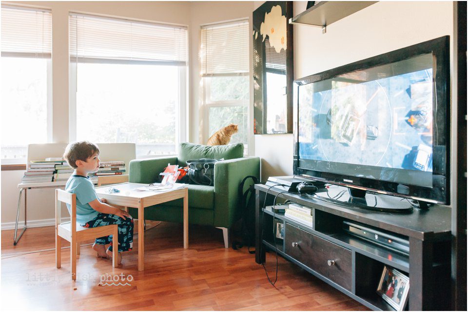 boy watches TV with cat