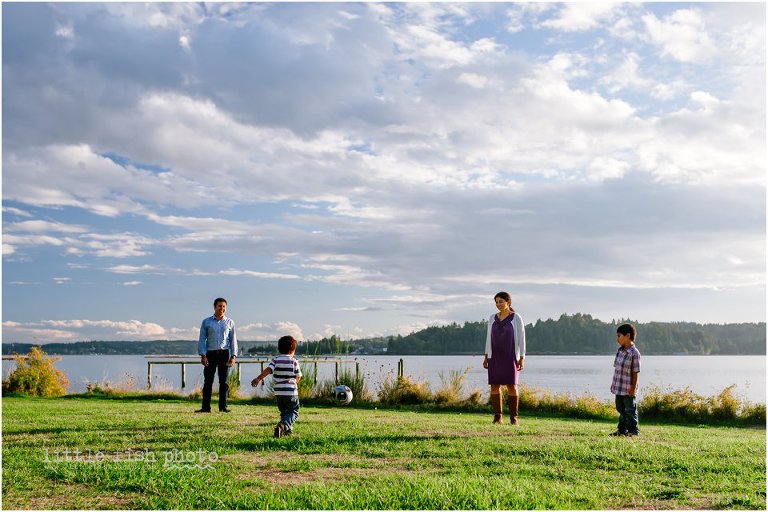 Family of four plays soccer at park