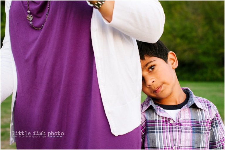 shy 5 year old boy hides behind mother