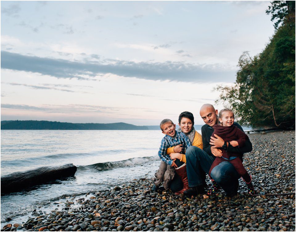 family of 4 plays on beach in fall