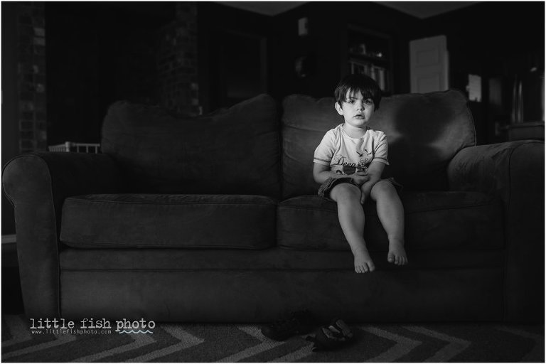 boy sits on couch with spot of light - Sham of the perfect