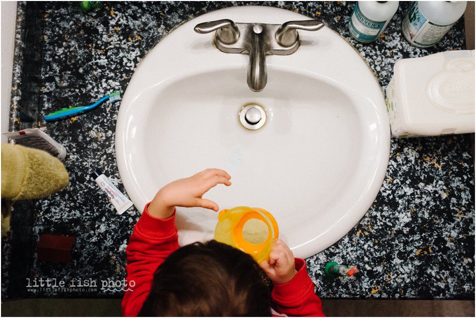 boy brushing teeth at bathroom sink