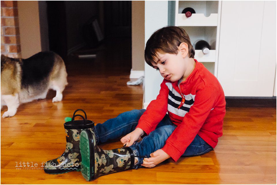 Sullen boy puts on boots