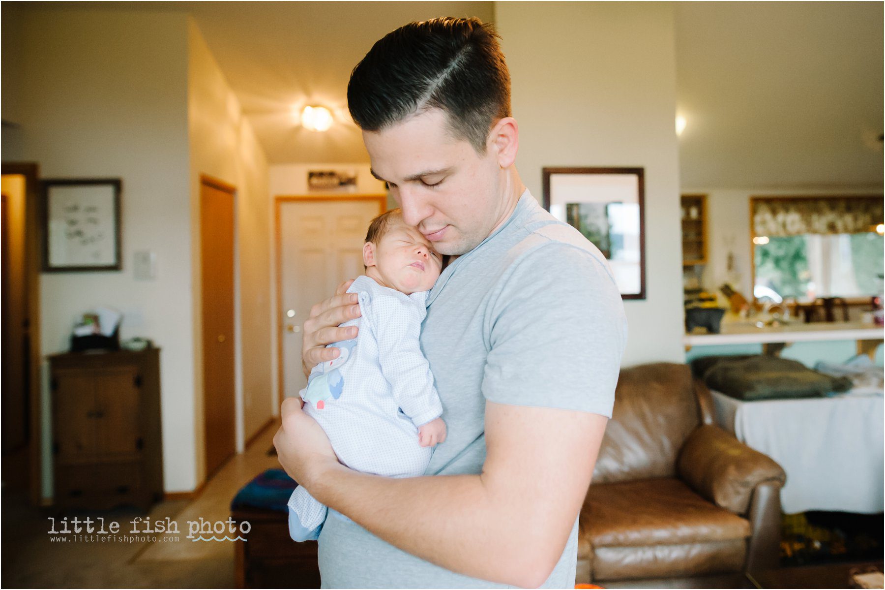 father cuddles with newborn baby