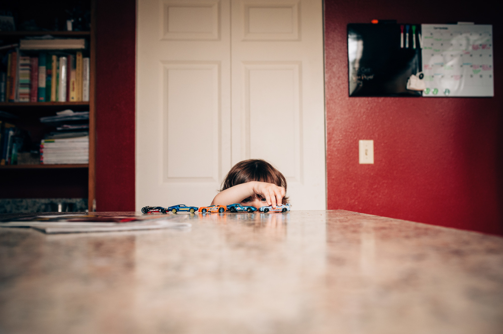 boy avoids dinner by hiding behind table