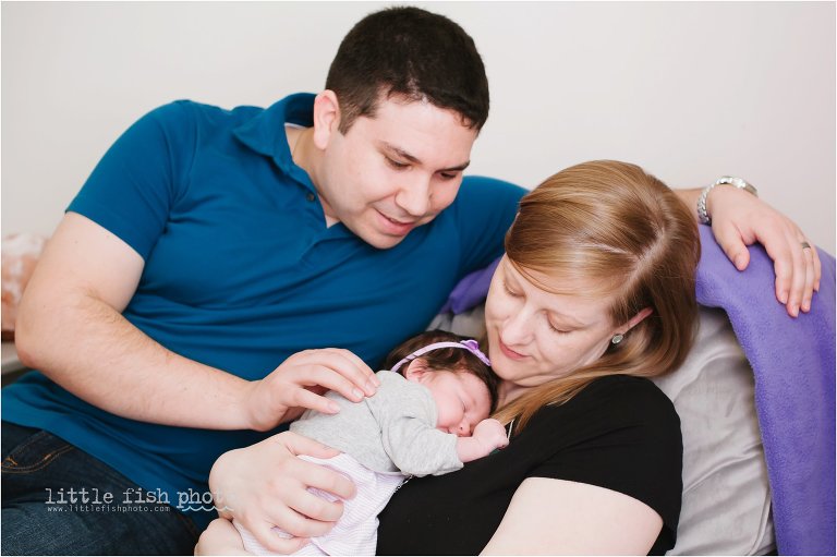 Family cuddles with newborn girl in nursery - Bremerton Lifestyle Newborn Photographer
