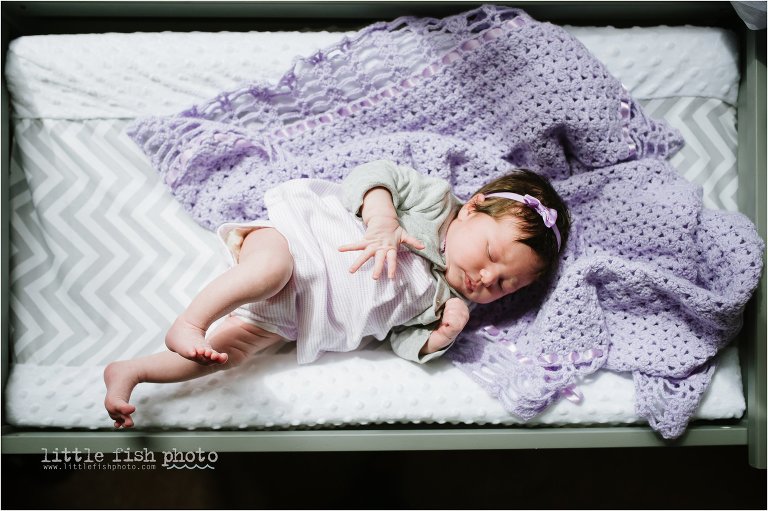 newborn girl stretches on changing table -Bremerton Lifestyle Newborn Photographer