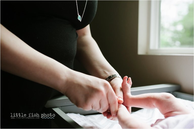 mother puts lotion on baby's feet - Bremerton Lifestyle Newborn Photographer