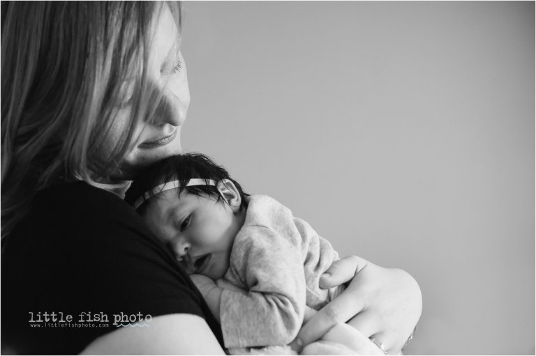 mother holds sleeping baby girl - Bremerton Lifestyle Newborn Photographer