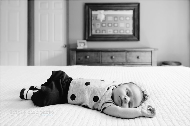 baby sleeps on bed in black and white