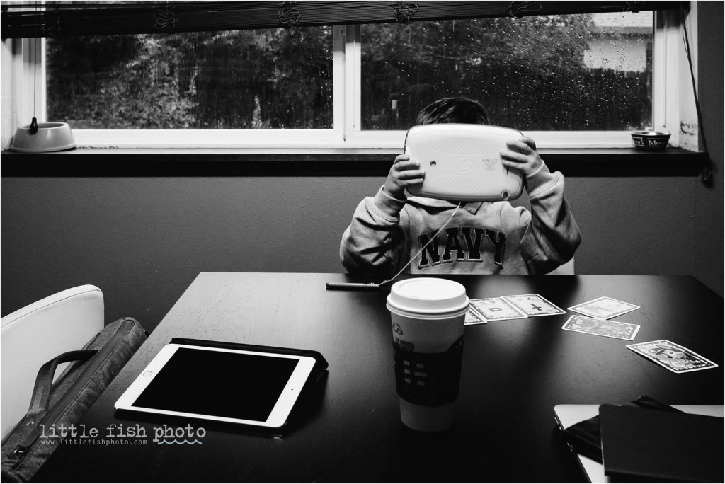 boy holds tablet in front of face - documentary family photography