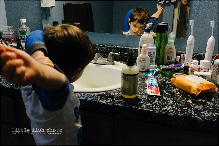 boy stretches in front of bathroom mirror - Documentary Family photography
