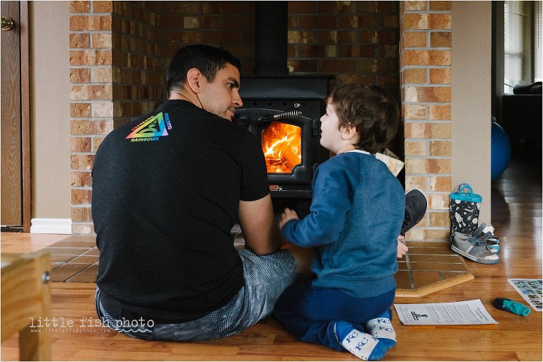father and son build fire in fireplace