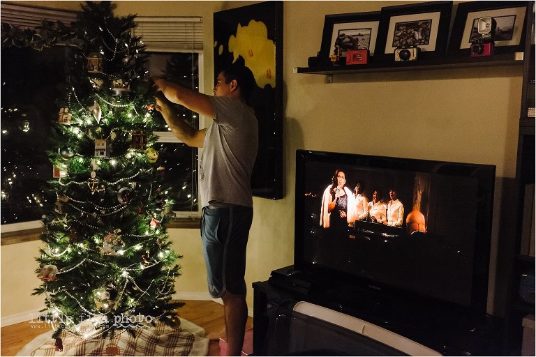 man decorates christmas tree