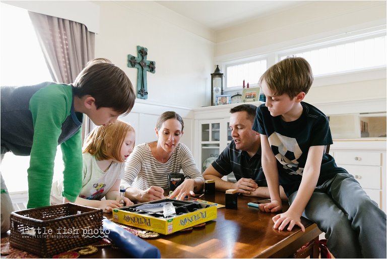 family plays game at dining table