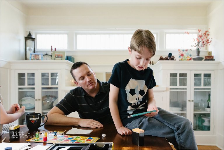 family plays game at dining table