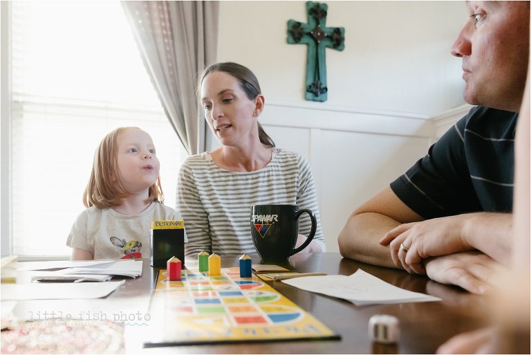 family plays game at dining table