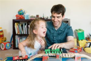 girl laughs as she plays with father
