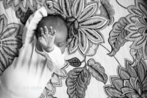 baby with hand in air - Kitsap Lifestyle Newborn Photographer