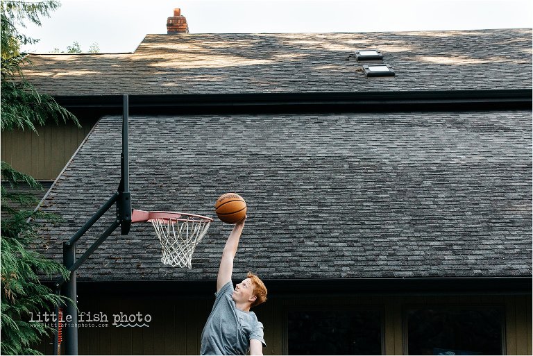 high school boy with red hair dunking basketball on driveway hoop - Bainbridge Island High School Senior Photographer