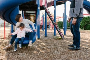 mom rides with daughter down slide - Kitsap Documentary Family Photographer