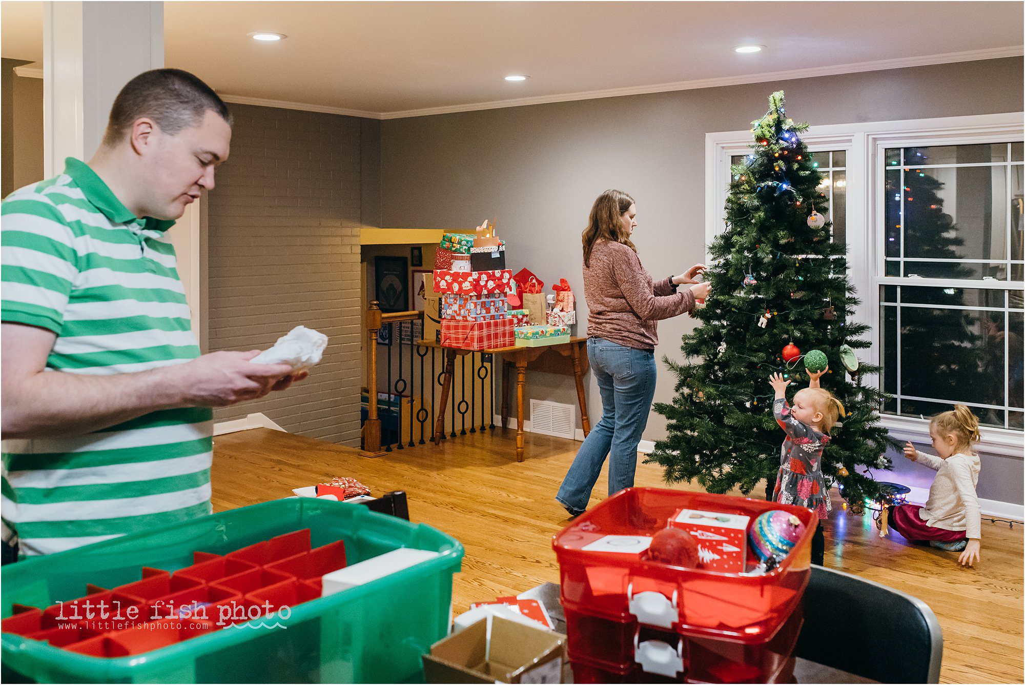 family with two little girls trims Christmas tree - Kansas City Documentary Family Photographer