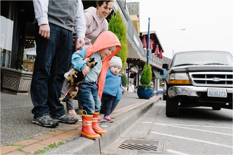 son looks down storm drain