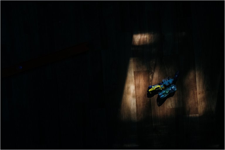 toy cars in spot of sunlight on floor - documentary family photography