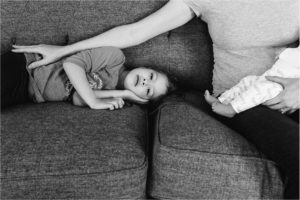 mother reaches for daughter while holding son - Kitsap Newborn Photography