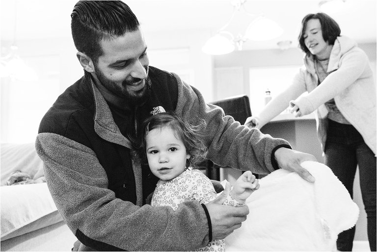 father helps daughter put on coat - Kitsap Family Photographer