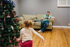 father on phone while girl dances - Lifestyle Family Photography