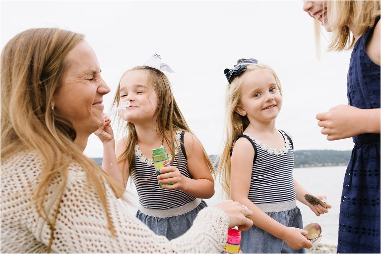 girl blows bubbles in mom's face