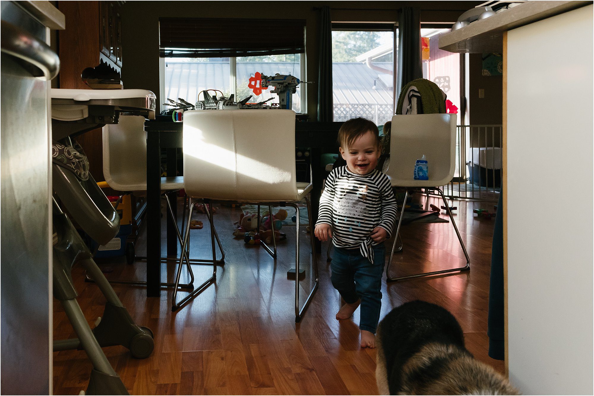 happy baby running through spot of sunlight -documentary family photography