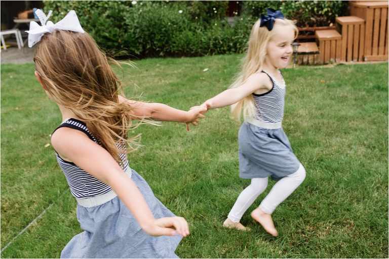 Documentary image of twin girls running and giving each other a high five.