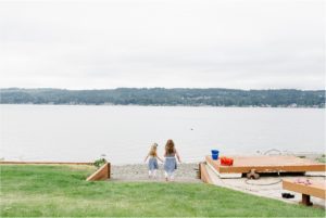 lifestyle image of twin girls approaching rocky shoreline in Bremerton Washington.