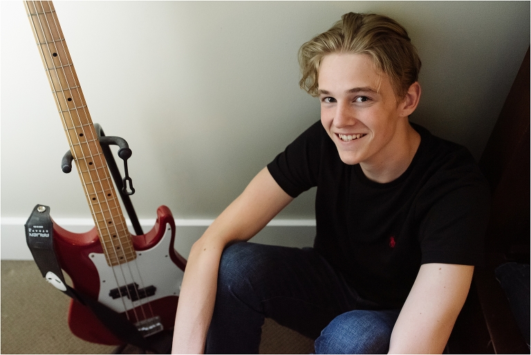 teen boy sits with guitar in his room - high school senior portrait - Bainbridge Island Photographer