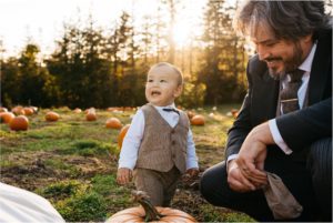 boy in suit with father in pumpkin patch